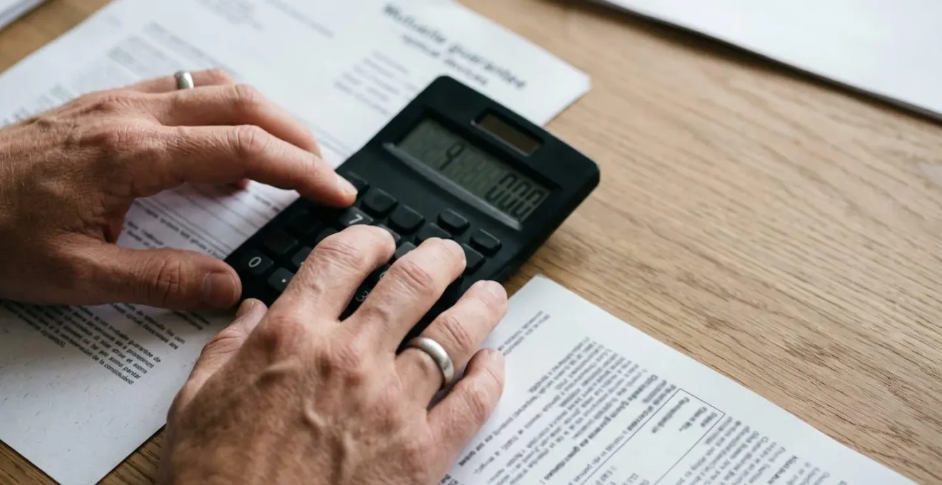 Gros plan sur des mains calculant un budget optique avec documents de remboursement